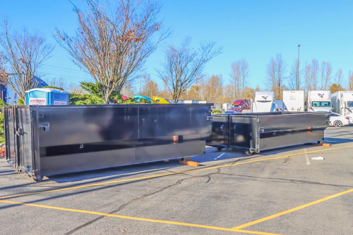 Professional dumpster rental service with roll-off container on residential driveway in Flower Hill